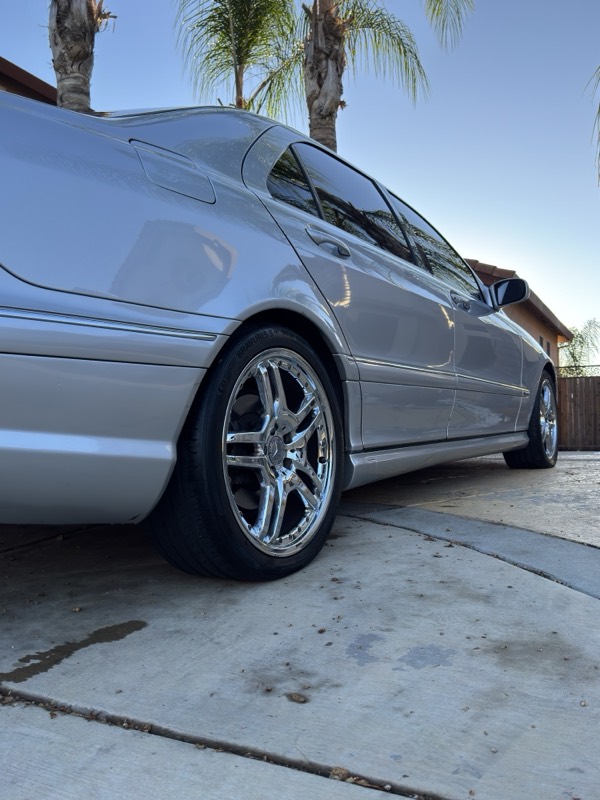 Silver sedan in an Elk Grove driveway after a full detail, paint and chrome wheels shining